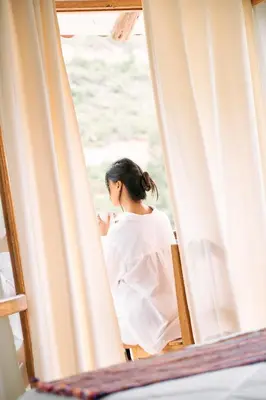 a woman sitting in a chair looking out a window at Sueños del Valle Sagrado in Urubamba