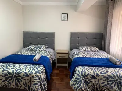 a bedroom with two beds with blue and white sheets at Centric & cozy apartment with Garage in Cusco