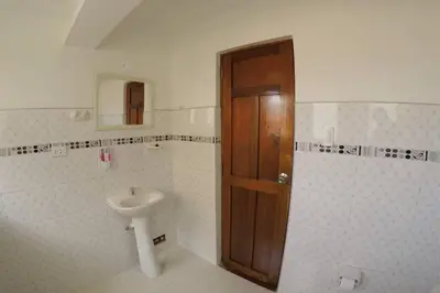 a bathroom with a sink and a wooden door at Centric & cozy apartment with Garage in Cusco