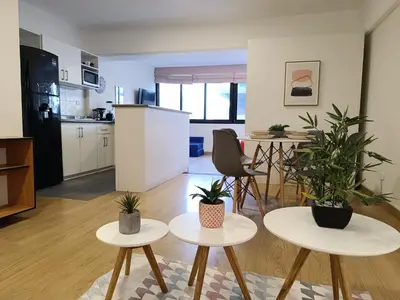 a kitchen and living room with two tables and potted plants at Runawasi Loft - Raywa 1 BDR, Centric and confortable. in Lima