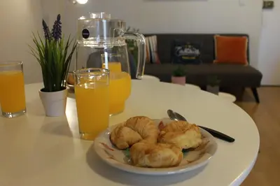 a plate of food on a table with two glasses of orange juice at Runawasi Loft - Raywa 1 BDR, Centric and confortable. in Lima