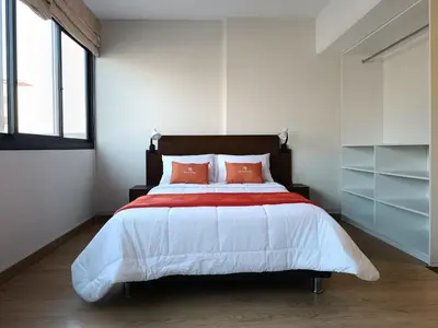 a bedroom with a large bed with orange pillows at Runawasi Loft - Raywa 1 BDR, Centric and confortable. in Lima