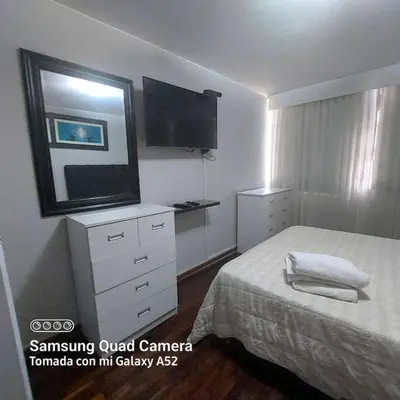 a bedroom with a bed and a flat screen tv at APARTAMENTO 502 in Lima