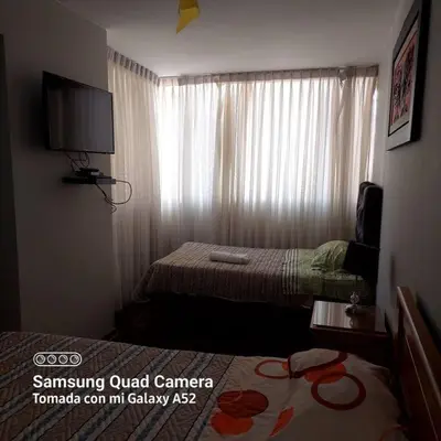 a hotel room with two beds and a window at APARTAMENTO 502 in Lima