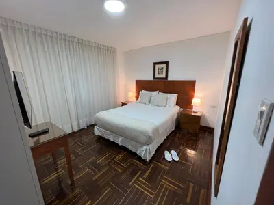 a hotel room with a bed and a television at San Isidro Olivar 2 bedroom Apartment in Lima