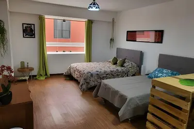 a bedroom with two beds and a window at Alojamiento San Francisco - Apartamentos y habitaciones in Lima