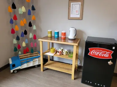 a small table next to a cocacola refrigerator at Alojamiento San Francisco - Apartamentos y habitaciones in Lima