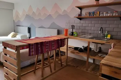 a kitchen with a table and a bed in a room at Alojamiento San Francisco - Apartamentos y habitaciones in Lima