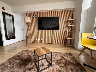 a living room with a television on a wall with a rug at Exclusivo con vista panorámica al mar - Ocean View in Lima