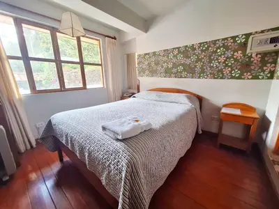 a bedroom with a bed with a white blanket at Andenes del Sol in Cusco