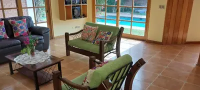 a living room with a couch and chairs and a table at Las buganvilias in Pachacamac