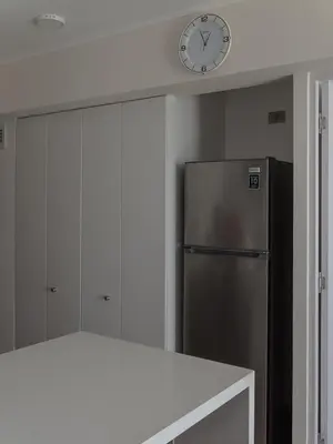 a kitchen with a refrigerator and a clock on the wall at Cozy 2BR Loft in the Heart of Miraflores in Lima
