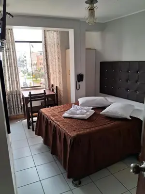 a bedroom with a bed with two towels on it at LAS ARTES INN in Lima