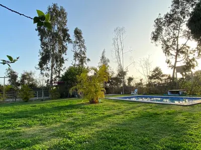 a swimming pool in a park with a grass field at Casa de campo con piscina en Asia in Asia