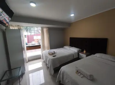 a bedroom with two beds and a window at Inti Llaqta Hotel & Suites in Lima