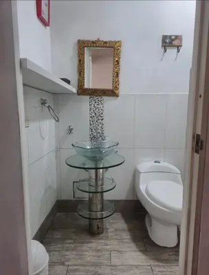 a bathroom with a sink and a toilet and a mirror at Depa Excelente Vintage in La Molina