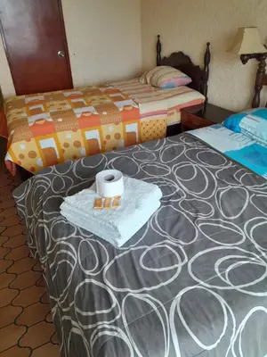 a hotel room with two beds and a towel on the bed at HOTEL CHORRILLOS BEACH in Barranca
