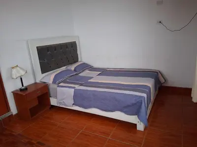 a bedroom with a bed with blue and white sheets at HOTEL CHORRILLOS BEACH in Barranca