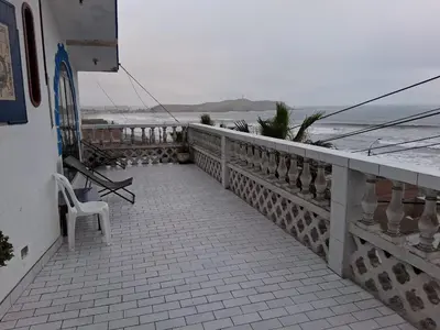 a balcony with a chair and the ocean in the background at HOTEL CHORRILLOS BEACH in Barranca