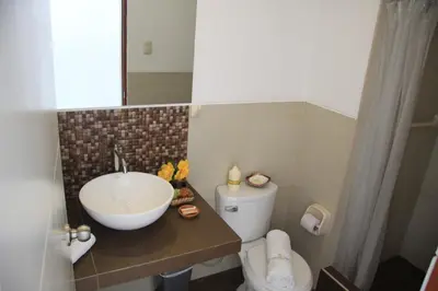 a bathroom with a sink and a toilet at Bamboo Lodge Paracas in Paracas