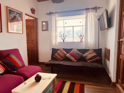 a living room with a couch and a window at Saqray Hostel in Cusco