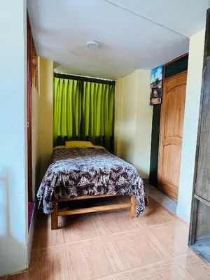 a bedroom with a bed with a green curtain at Euro Hostal in Cusco