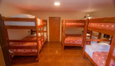a room with four bunk beds and a hallway at Casa Machu Picchu Hostel in Machu Picchu