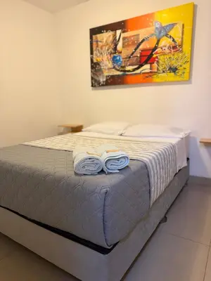 a bed with two flip flops on top of it at SG Paracas Hostel in Paracas