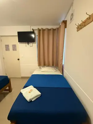 a bedroom with a blue bed with a towel on it at SG Paracas Hostel in Paracas