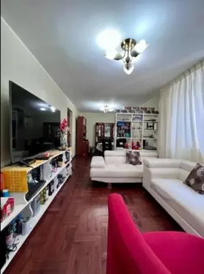 a living room with white couches and a red chair at Siempre Listo in Lima