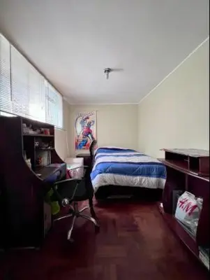 a bedroom with a bed and a desk and a chair at Siempre Listo in Lima
