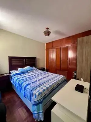 a bedroom with a bed and a white desk at Siempre Listo in Lima