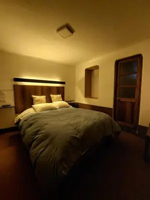 a bedroom with a large bed with a wooden headboard at Mirador de la Ñusta in Cusco