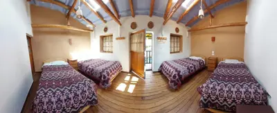 a room with two beds in a building at Mirador de la Ñusta in Cusco