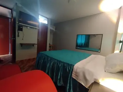 a hotel room with a bed and a tv at Hostal El Pilar in Lima
