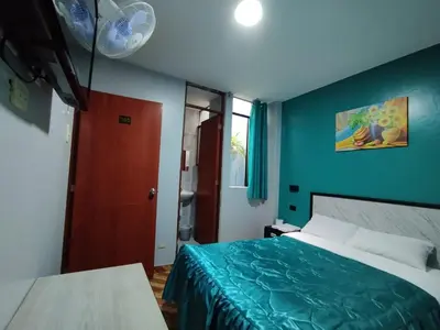 a bedroom with a bed and a blue wall at Hostal El Pilar in Lima