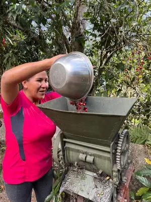 a woman holding a pot on top of a mixer at Refugio de Mery Lucmabamba in Sahuayacu