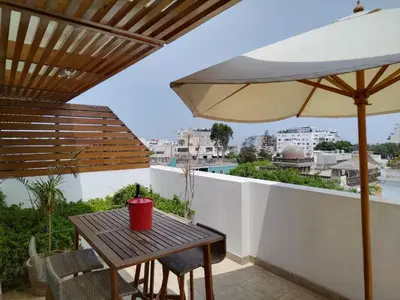 a table and an umbrella on a balcony at Moderno departamento cerca al malecón in Lima