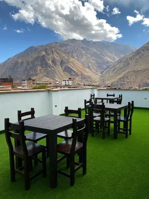 a row of tables and chairs with mountains in the background at Hotel Sol de Canta in Canta