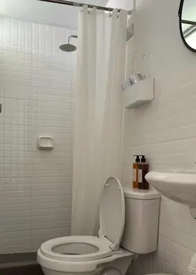 a white bathroom with a toilet and a sink at Hotel Sol de Canta in Canta
