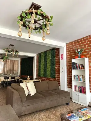 a living room with a couch and a brick wall at Hotel Sol de Canta in Canta