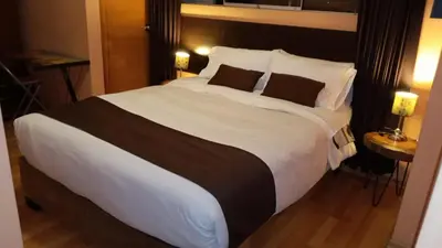 a large white bed in a hotel room at CasaHotel El Tambo Huancayo in Huancayo