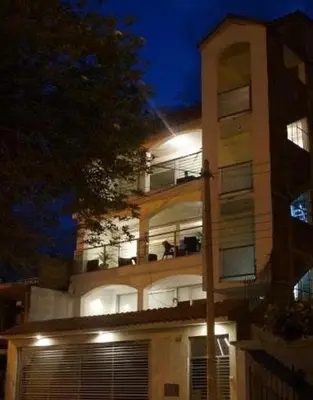a tall building with a balcony at night at CasaHotel El Tambo Huancayo in Huancayo