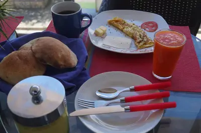 a table with plates of food and a cup of coffee at CasaHotel El Tambo Huancayo in Huancayo