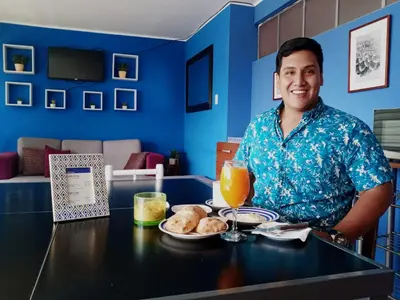a man sitting at a table with a plate of food at CasaHotel El Tambo Huancayo in Huancayo