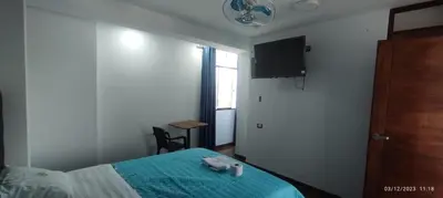 a bedroom with a bed and a tv on the wall at Hotel Grand Paradise Marcona in San Juan de Marcona