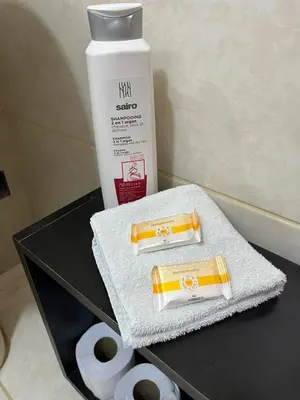 a black table with a bottle of soap and towels at Harmony Inn Miraflores in Lima