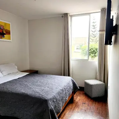 a small bedroom with a bed and a window at Casa Cultura in Lima