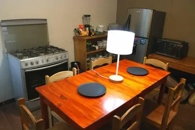 a kitchen with a wooden table and a stove at Nico Homes in Cusco