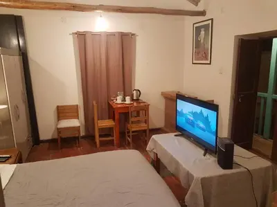 a living room with a flat screen tv and a table at Nico Homes in Cusco